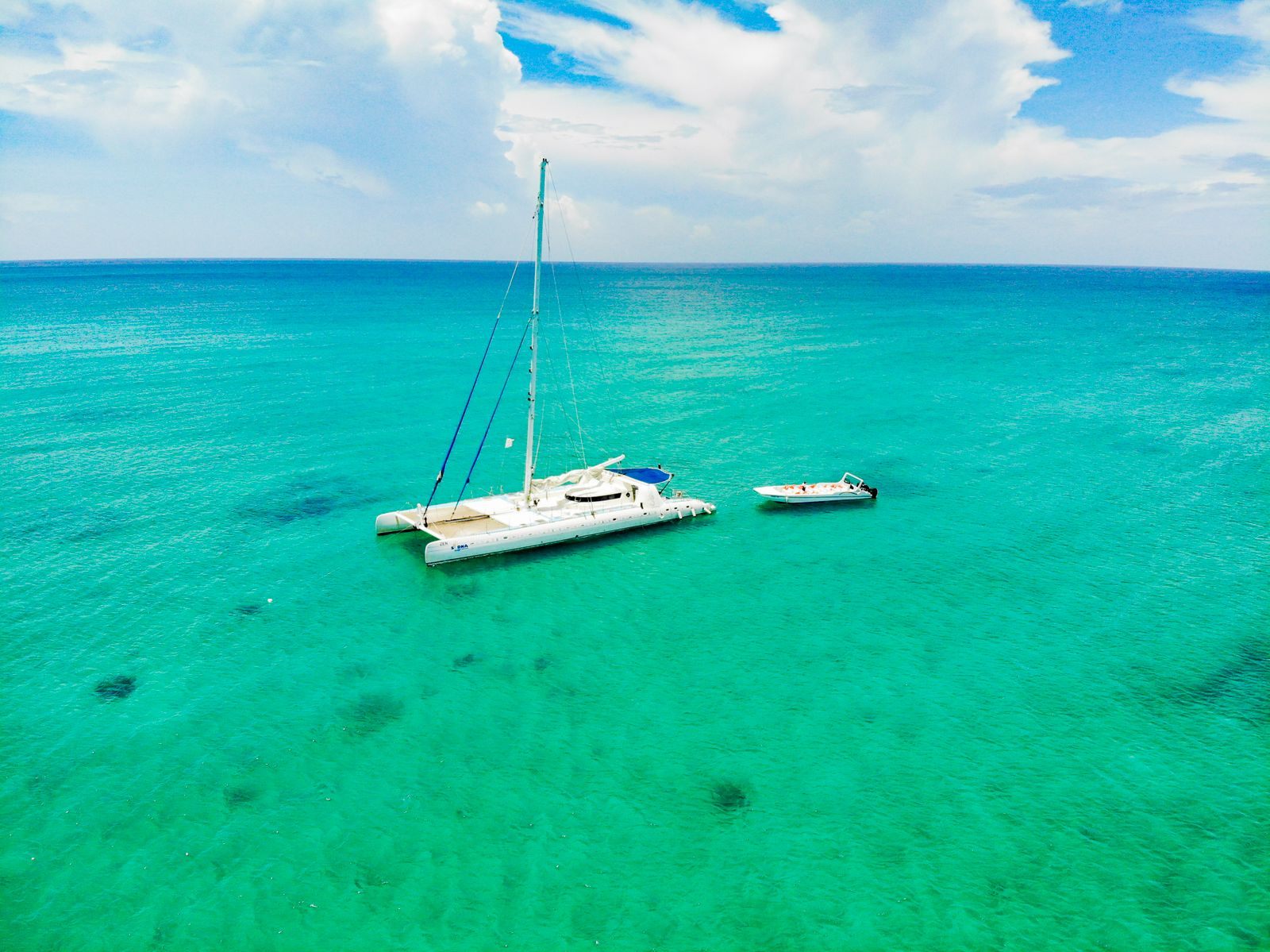 Catamaran anchored in bright turquoise tropical water, the setting for group sailing trips in the Caribbean
