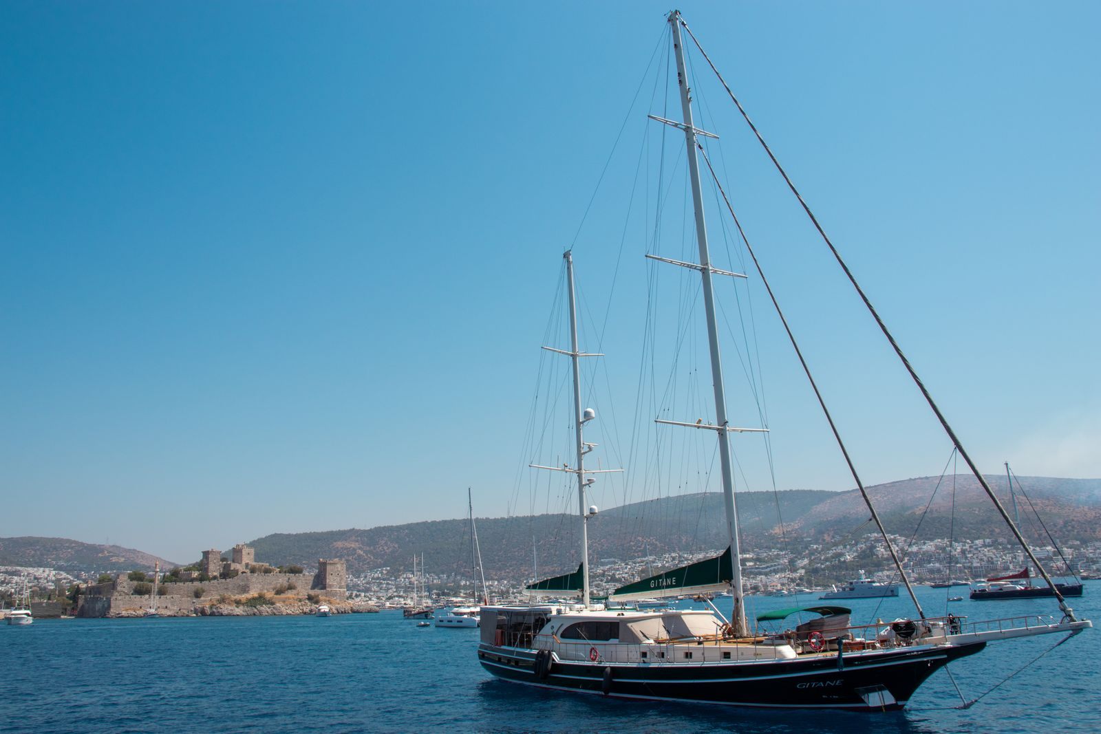 Two-masted gulet sailing past Bodrum Castle, a classic start for a gulet charter in Turkey